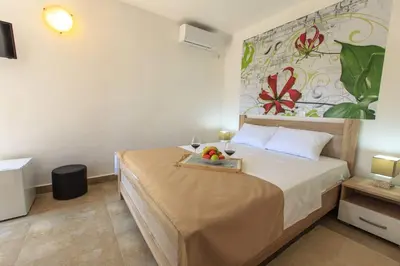 a bedroom with a bed with a tray of fruit on it at Riva Lux Apartments in Sutomore