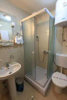 a bathroom with a shower and a toilet and a sink at Riva Lux Apartments in Sutomore