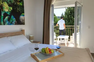 a bedroom with a bed with a tray of fruit and wine glasses at Riva Lux Apartments in Sutomore