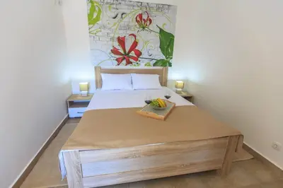 a bedroom with a bed with a tray of fruit on it at Riva Lux Apartments in Sutomore
