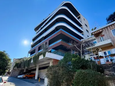 a tall building with a car parked in front of it at Royal Residence Penthouse - Budva, Center in Budva