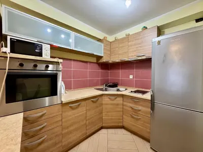 a kitchen with wooden cabinets and a stainless steel refrigerator at Panoramic Sea View - Two Bedroom Apartment - Budva Center in Budva
