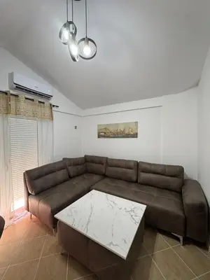 a living room with a brown couch and a table at Apartman Sunce in Budva