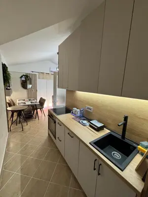 a kitchen with a sink and a dining room at Apartman Sunce in Budva