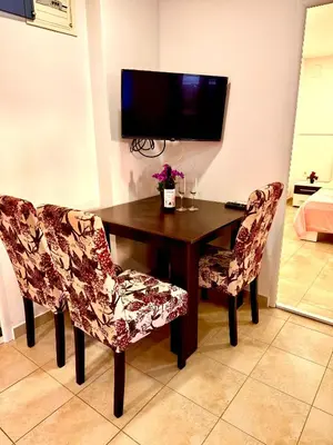 a dining room table with two chairs and a television at Adriatic Stay Apartments in Budva