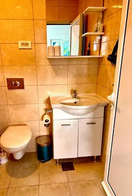 a bathroom with a sink and a toilet and a mirror at Adriatic Stay Apartments in Budva