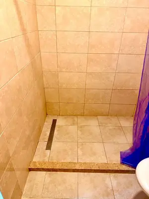 a shower with a tiled floor in a bathroom at Adriatic Stay Apartments in Budva