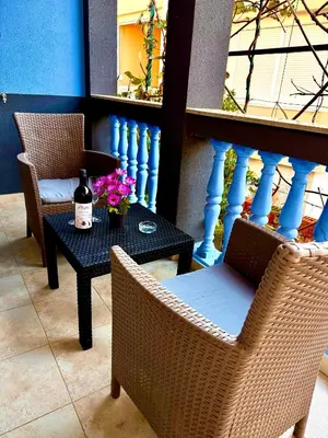 a patio with two chairs and a table with a bottle of wine at Adriatic Stay Apartments in Budva