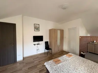 a bedroom with a bed and a chair and a television at Solis Apartments Sutomore in Sutomore