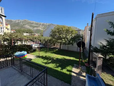 a balcony with a yard with grass and a fence at Solis Apartments Sutomore in Sutomore