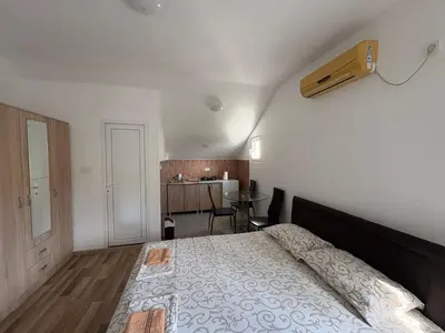 a bedroom with a large bed and a kitchen at Solis Apartments Sutomore in Sutomore