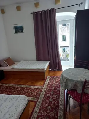 a room with a bed and a table and a window at Apartman Nikoleta in Kotor