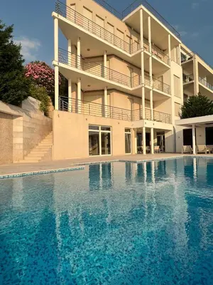 a large swimming pool in front of a building at Villa Jelena in Reževići