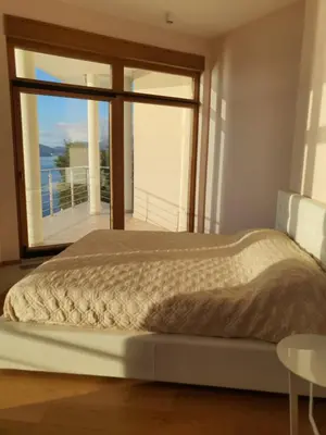 a bed in a bedroom with a large window at Villa Jelena in Reževići