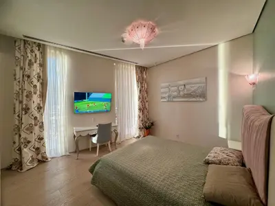 a bedroom with a bed and a desk and a television at Exclusive Luxury Villa in Dukley Gardens in Budva