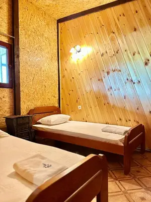 a room with two beds and a wooden wall at Amazonas Pirates 3 in Ulcinj