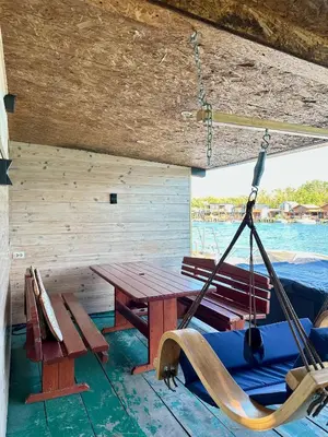 a porch with a wooden table and a swing at Amazonas Pirates 3 in Ulcinj