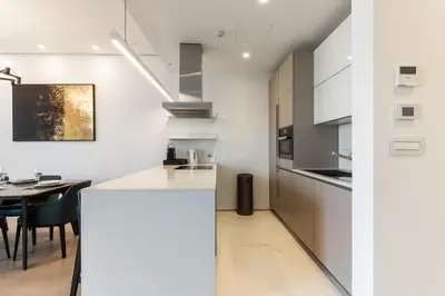 a kitchen with white walls and a dining room with a table at Luxury Dukley Villa in Boreti