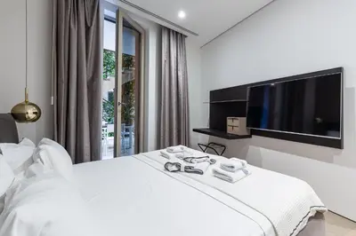 a bedroom with a white bed and a flat screen tv at Luxury Dukley Villa in Boreti