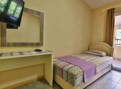a small bedroom with a bed and a mirror at Beachfront Sunset Apartments Sutomore in Brca