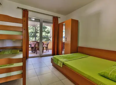 a bedroom with a bed and a dining room at Beachfront Sunset Apartments Sutomore in Brca