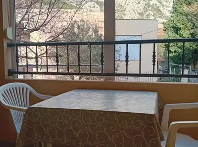 a balcony with a table and a large window at Beachfront Sunset Apartments Sutomore in Brca