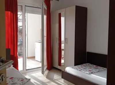 a bedroom with a bed and a sliding glass door at Beachfront Sunset Apartments Sutomore in Brca