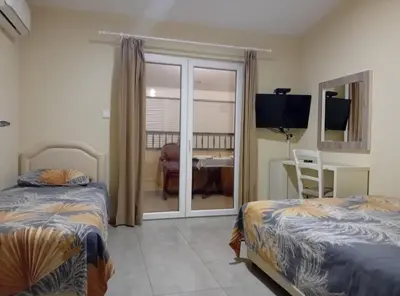 a bedroom with two beds and a sliding glass door at Beachfront Sunset Apartments Sutomore in Brca