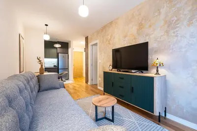 a living room with a couch and a flat screen tv at Fratello Apartment in Podgorica