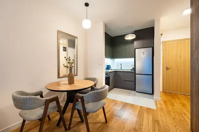 a kitchen and dining room with a table and chairs at Fratello Apartment in Podgorica