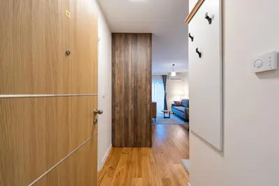 a hallway with a door and a living room at Fratello Apartment in Podgorica