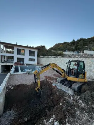 a yellow excavator in front of a house at Villa & Pool in Utjeha