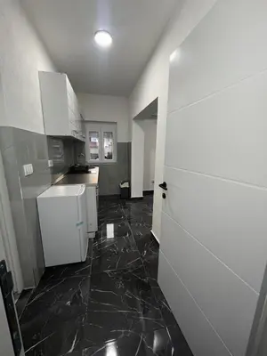 a kitchen with white cabinets and a black tile floor at rent stan sutomore in Sutomore