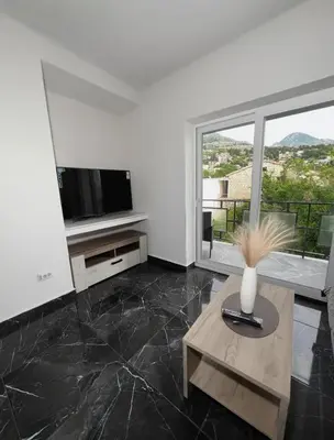 a living room with a television and a vase on a table at rent stan sutomore in Sutomore