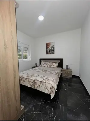 a bedroom with a bed and a black tile floor at rent stan sutomore in Sutomore