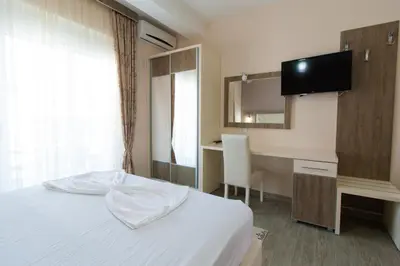 a bedroom with a bed and a desk and a television at A3 Apartments in Ulcinj