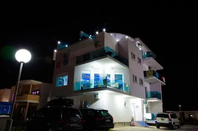 a building with cars parked in front of it at night at A3 Apartments in Ulcinj