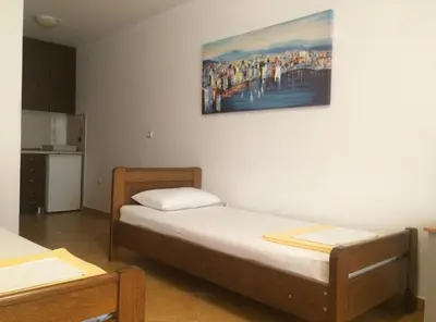 a room with two beds and a painting on the wall at Apartments Aleksić, Bečići in Becici