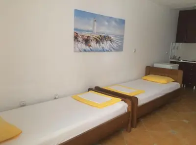 two beds in a room with a painting on the wall at Apartments Aleksić, Bečići in Becici