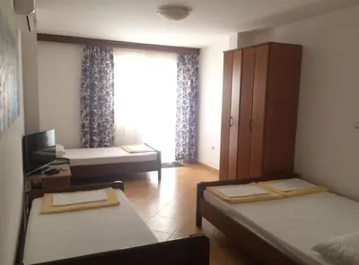 a small room with two beds and a window at Apartments Aleksić, Bečići in Becici