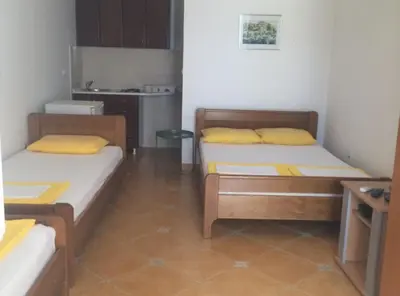 two beds in a small room with a kitchen at Apartments Aleksić, Bečići in Becici