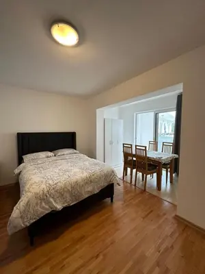a bedroom with a bed and a dining room with a table at Apartmani Bulevar Budva in Budva