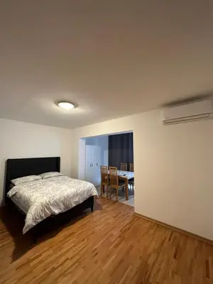 a bedroom with a bed and a dining room with a table at Apartmani Bulevar Budva in Budva