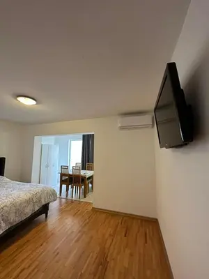 a bedroom with a bed and a television on the wall at Apartmani Bulevar Budva in Budva