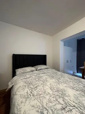 a bedroom with a bed with a black headboard at Apartmani Bulevar Budva in Budva