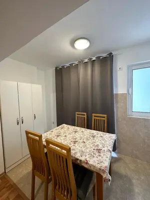 a dining room with a table and chairs and a window at Apartmani Bulevar Budva in Budva