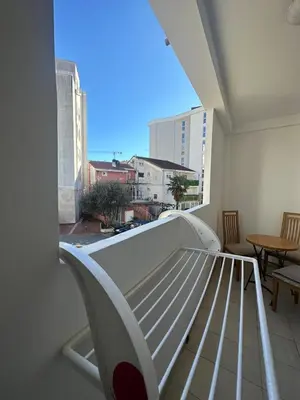 a balcony with a bed and a view of a city at Apartmani Bulevar Budva in Budva