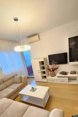 a living room with a couch and a tv at Central Light Apartment in Podgorica