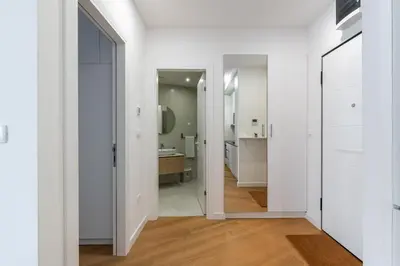a hallway with white walls and a bathroom at Stunning Bečići Apartment in Becici
