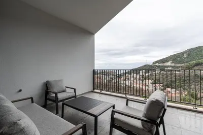 a balcony with two chairs and a table and a view at Stunning Bečići Apartment in Becici